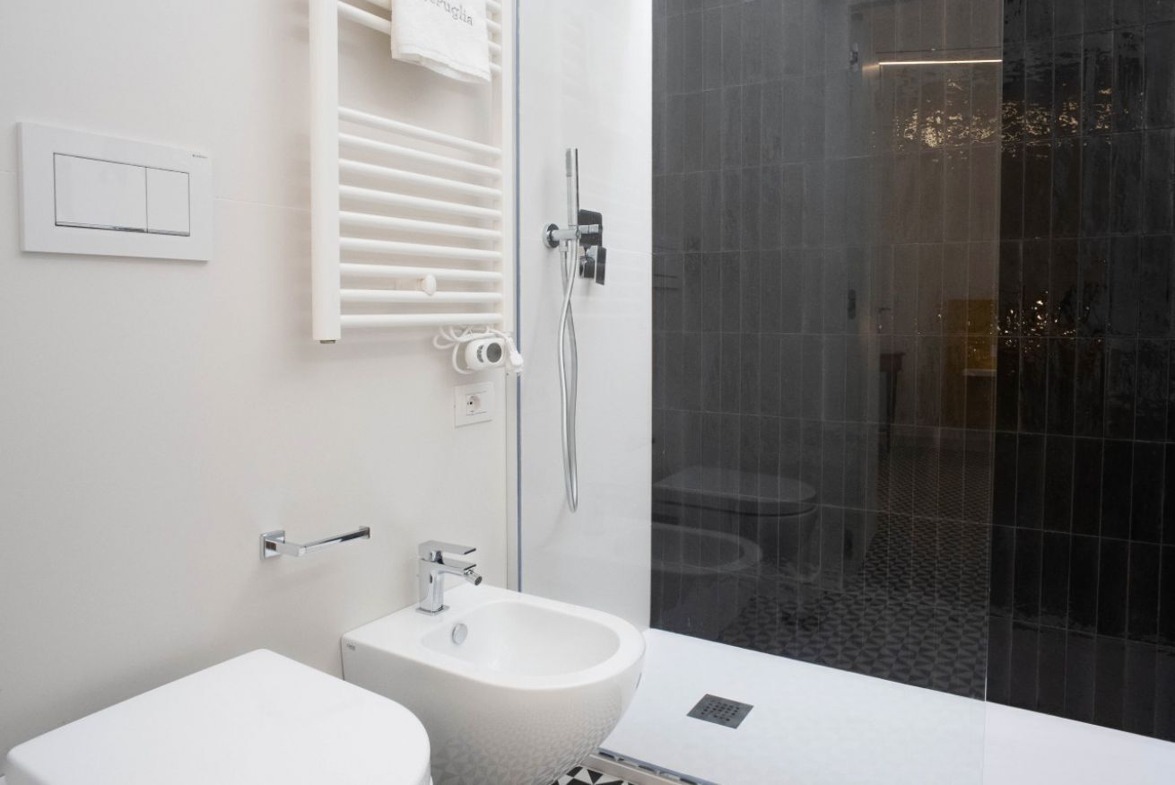 A modern bathroom with a toilet, bidet, and shower.