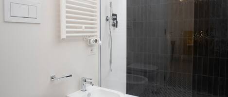 A modern bathroom with a toilet, bidet, and shower.