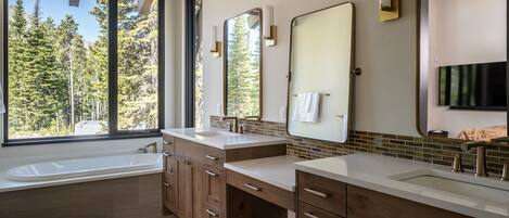 A modern bathroom with two sinks, wooden cabinets, and large mirrors.