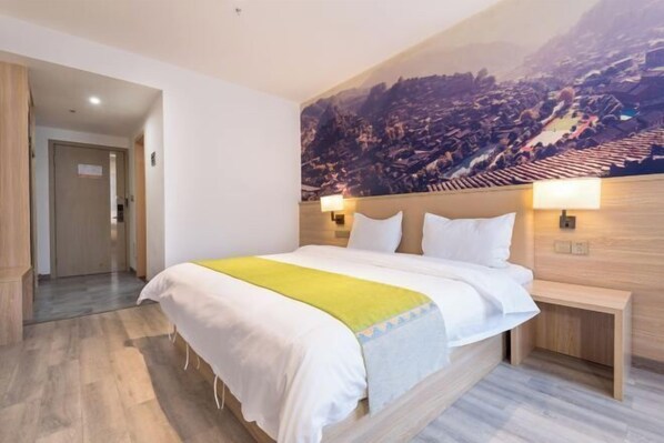 Una habitación de hotel con una cama grande, un cabecero de madera, dos mesitas de noche y un mural con vistas a la ciudad en la pared.