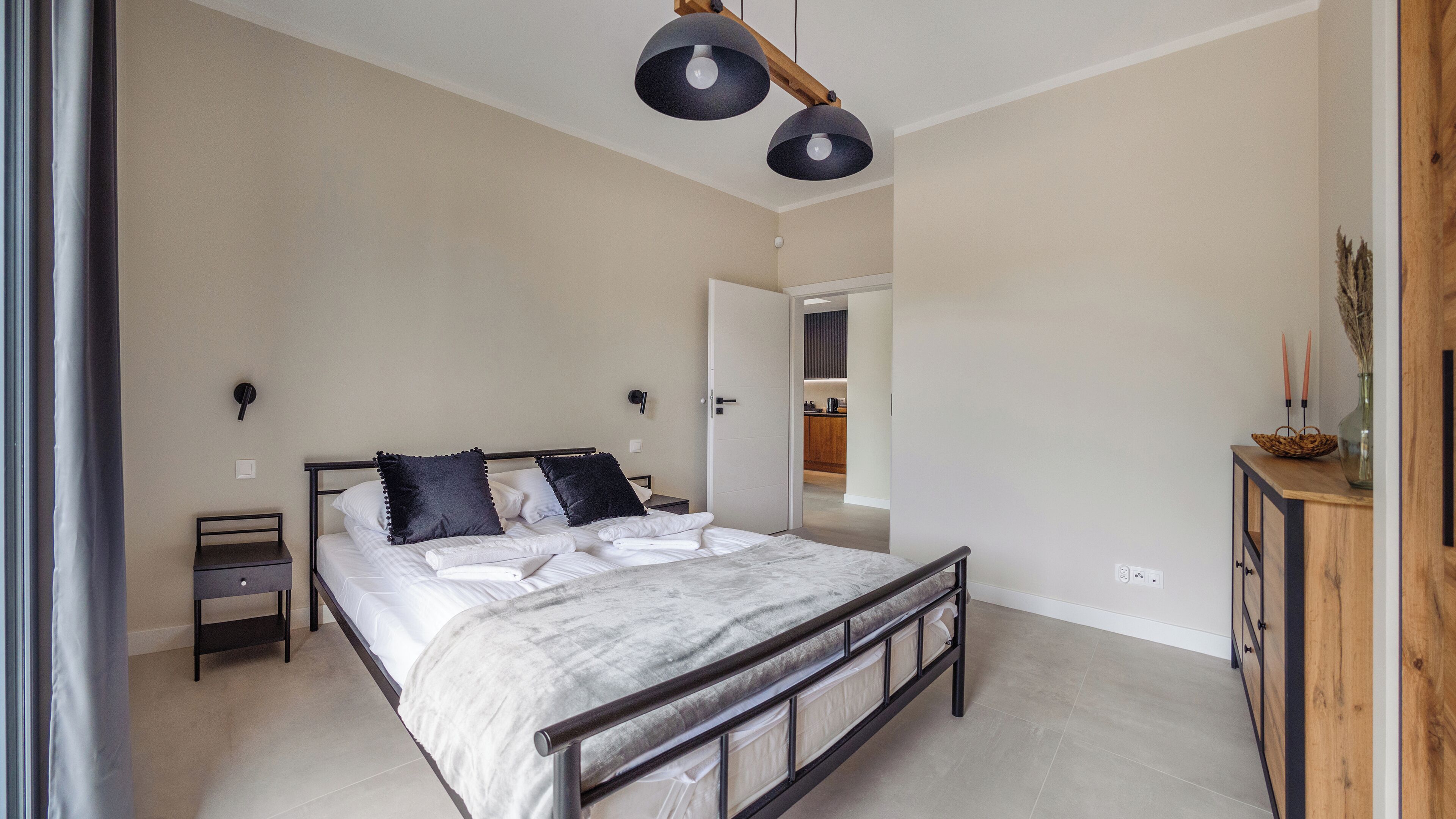 Un dormitorio con cama, mesitas de noche, armario y lámpara de techo.