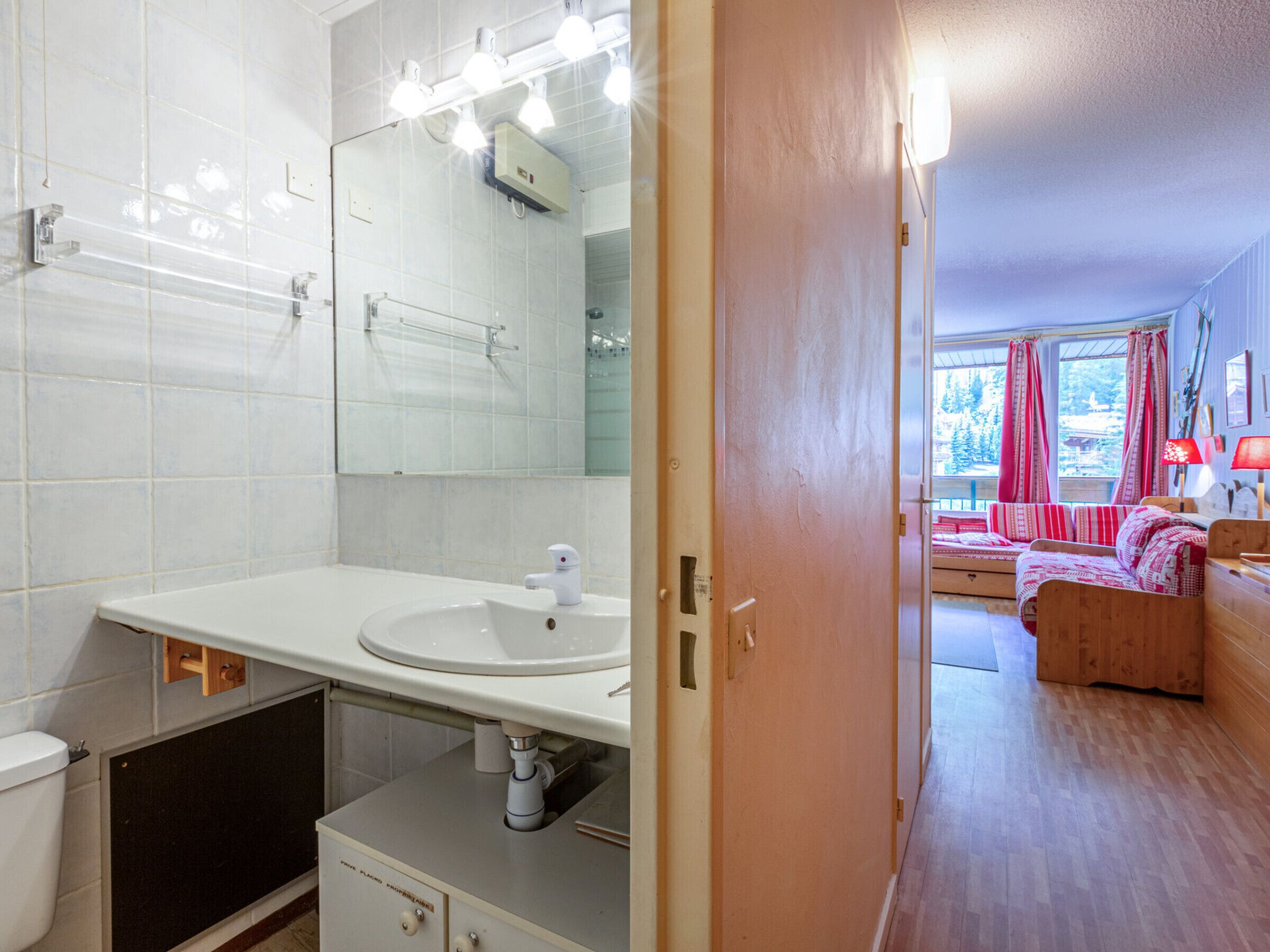Een badkamer met een witte wastafel, spiegel en toilet.