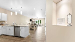 Una cocina moderna con una isla central, armarios blancos y una zona de comedor con mesa y sillas.