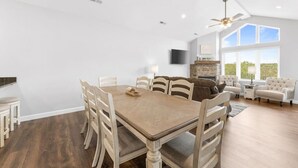 A spacious living area with a dining table, chairs, a sofa, and a fireplace.