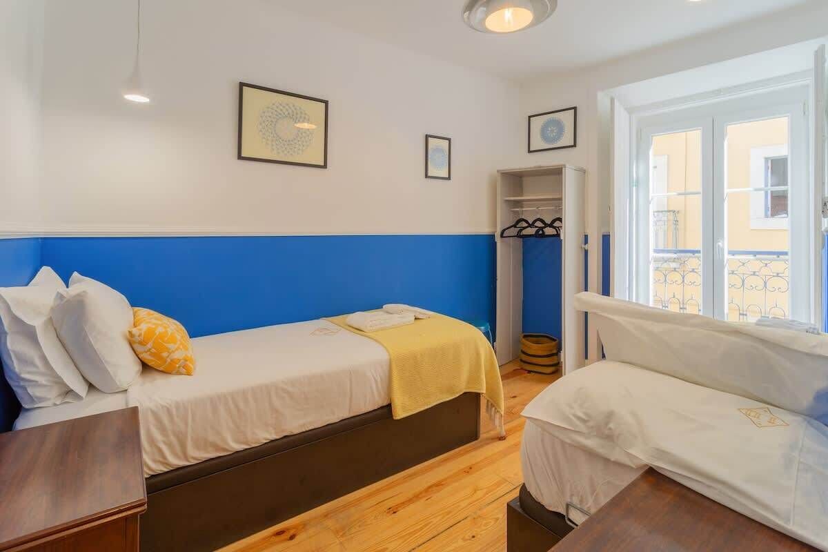 Una habitación con dos camas, un armario y una ventana con vistas.
