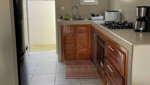 Une cuisine équipée d’un réfrigérateur, d’une cuisinière, d’un évier et de meubles de rangement en bois.