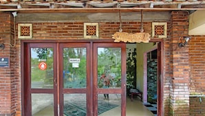 A brick building with a wooden door and a sign that reads "Telongpo 1". - Hotel O Kopi Klotok Homestay Syariah (Secang)