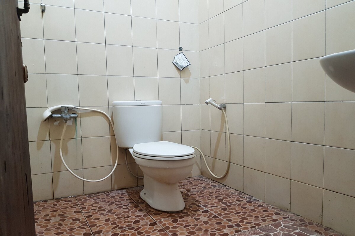 A bathroom with a toilet, a shower, and a sink.