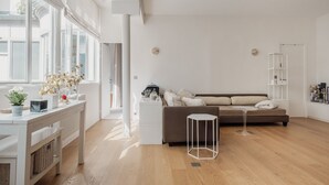 Un salon moderne comprenant un canapé, une table basse, une table d’appoint et un radiateur.