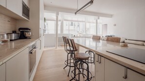 Une cuisine moderne dotée d’un îlot central, de tabourets de bar et d’un coin repas avec un canapé.