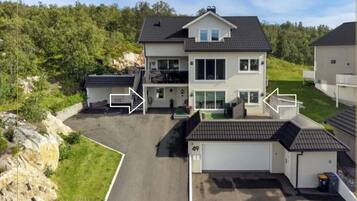 A two-story house with a garage, a driveway, and a small attached structure.