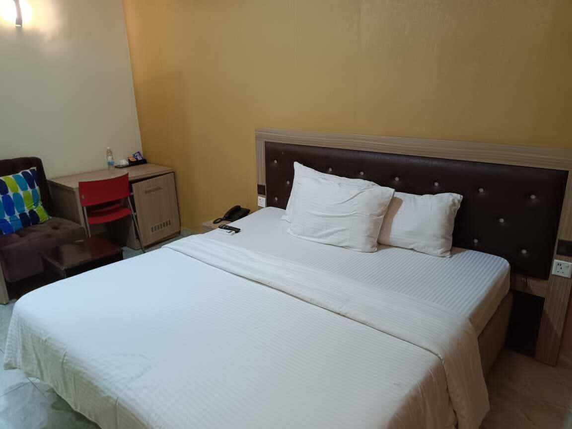 Una habitació d'hotel amb un llit, un escriptori i una cadira.