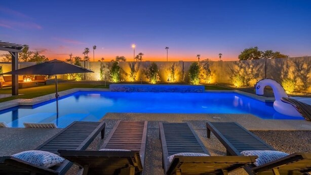 A swimming pool with lounge chairs and a decorative swan float. - BackyardOasis - FamilyRetreat Villa - HeatedPool (Phoenix)