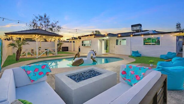 A backyard with a swimming pool, outdoor seating, and a covered patio area. - The No Bad Days Villa - Family Retreat -Central (Phoenix)