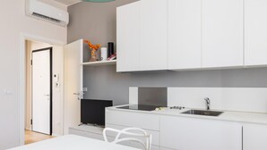 A modern kitchen with white cabinetry, a built-in stove, and a sink. - Crociali Apartment by Wonderful Italy (Bologna)