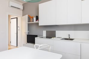 A modern kitchen with white cabinetry, a built-in stove, and a sink. - Crociali Apartment by Wonderful Italy (Bologna)
