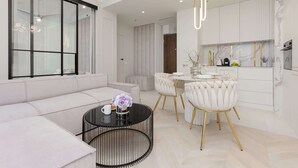 A modern living room with a sofa, a round coffee table, and a dining area with a table and chairs.