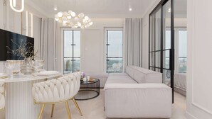 A modern living room with a sofa, a round dining table, and a TV mounted on the wall.