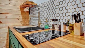A kitchen with a wooden countertop, a sink, and a hexagonal patterned backsplash.
