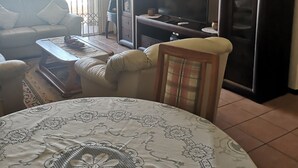 Una sala de estar con sofá, mesa de centro, mueble para televisión y aparador.
