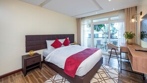 A modern hotel room with a large bed, a desk, and a balcony with a view. - Roma Courts Serviced Apartments (Nairobi)