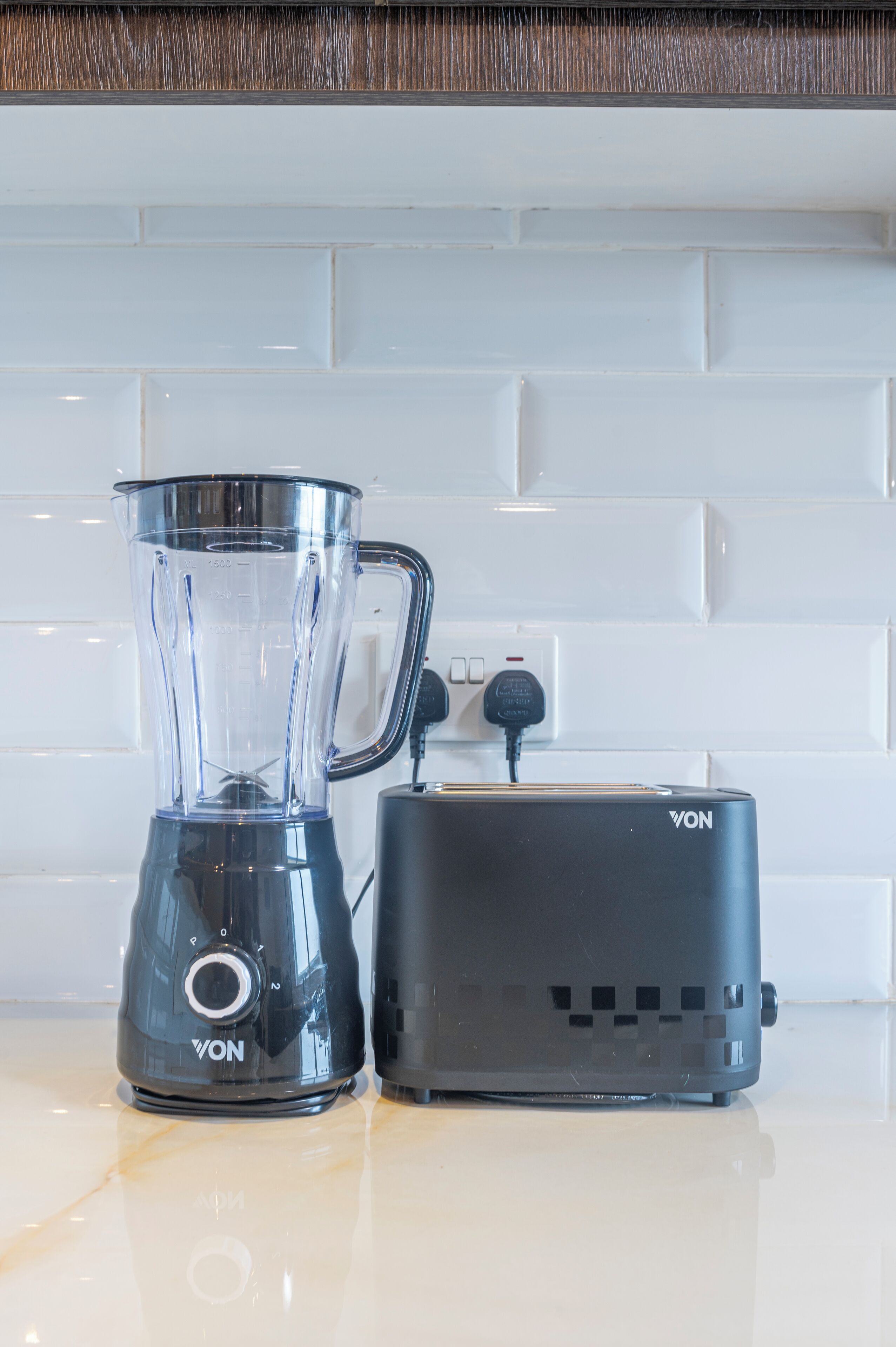 A kitchen with a blender and toaster on the counter.