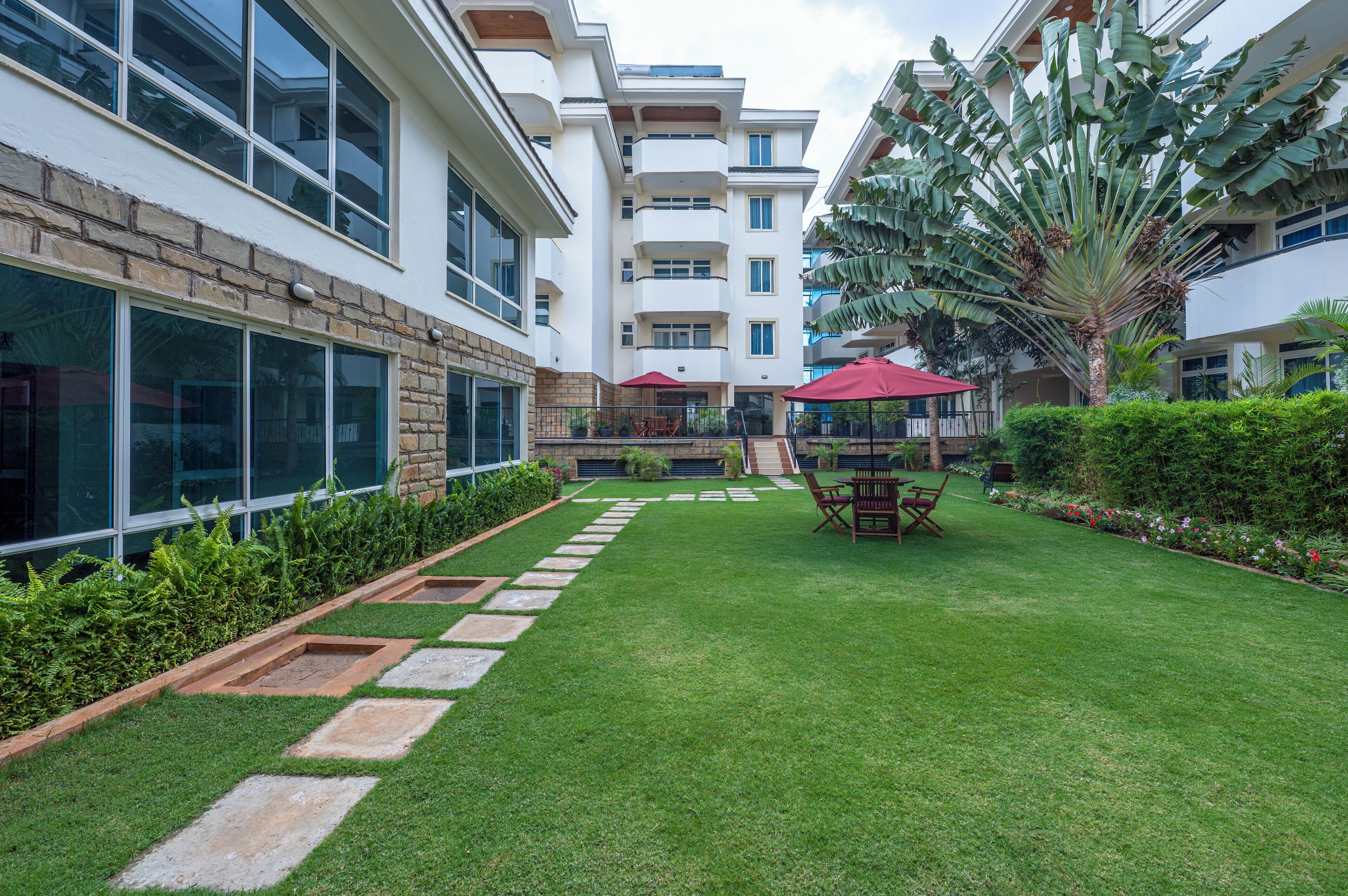 A courtyard with a well-maintained lawn, stone pathways, and outdoor furniture.