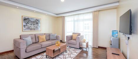 Een moderne woonkamer met een bank, salontafel en televisie.