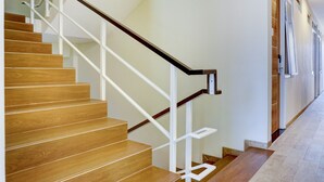 Una escalera con escalones de madera y barandillas blancas.