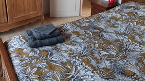 Un dormitorio con cama, armario de madera y puerta que da a otra habitación.
