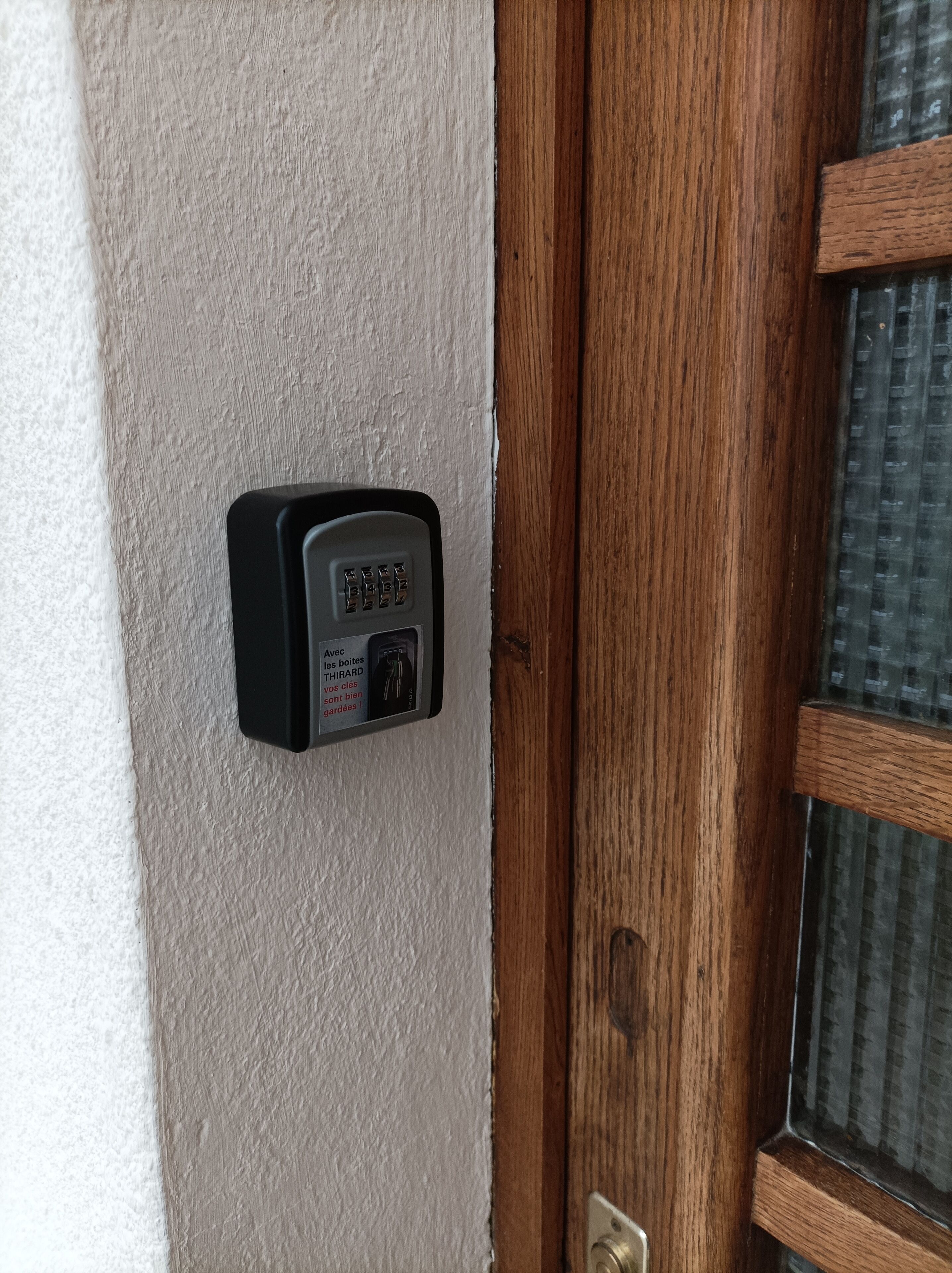 Een deurbel met een numeriek keypad en een Frans label.