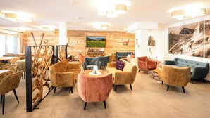 Un moderno vestíbulo de hotel con paredes de madera, asientos cómodos y obras de arte.