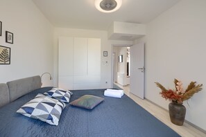 A bedroom with a bed, pillows, a bedside lamp, and a vase with dried flowers. - House Bronzin by Istra Vacation (Kanfanar)
