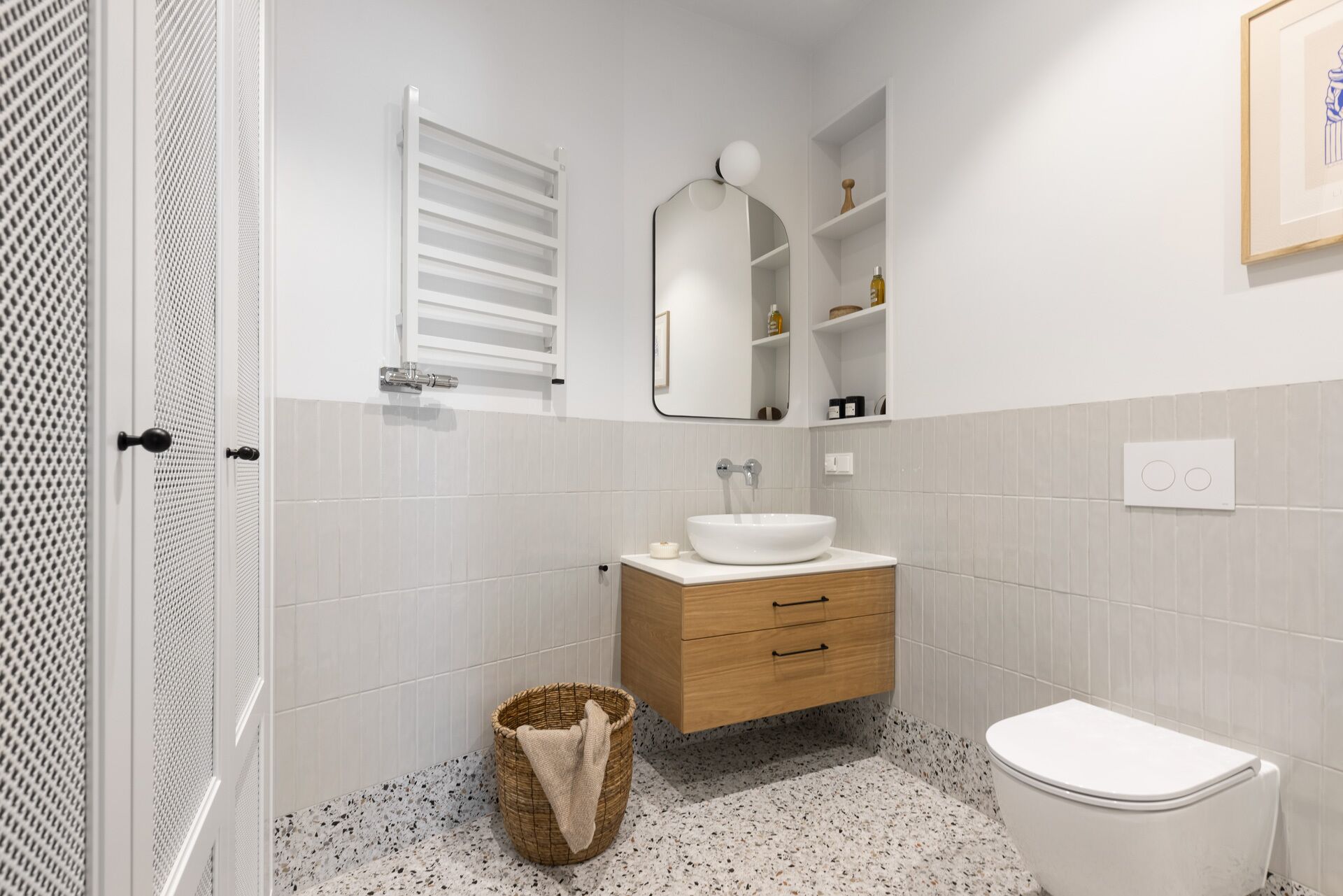 Une salle de bain moderne avec un lavabo blanc, un meuble-lavabo en bois et des toilettes blanches.
