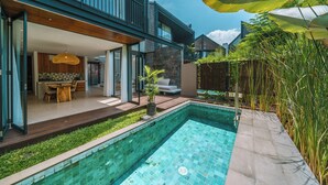 Ein modernes Haus mit Swimmingpool, einer Holzterrasse und einem Essbereich.