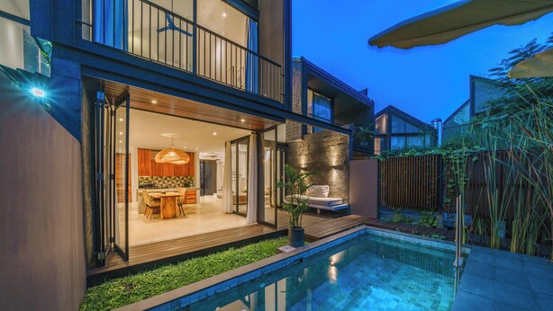 Ein modernes Haus mit Schwimmbad, Essbereich und Terrasse.