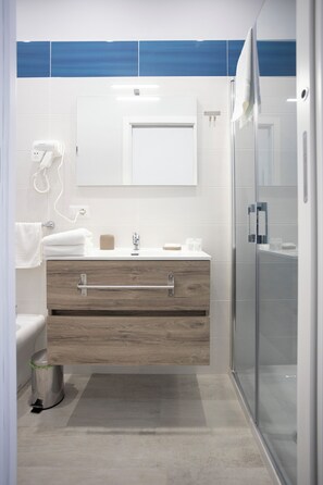 Habitación cuádruple Deluxe | Baño | Ducha y cabezal de ducha tipo lluvia