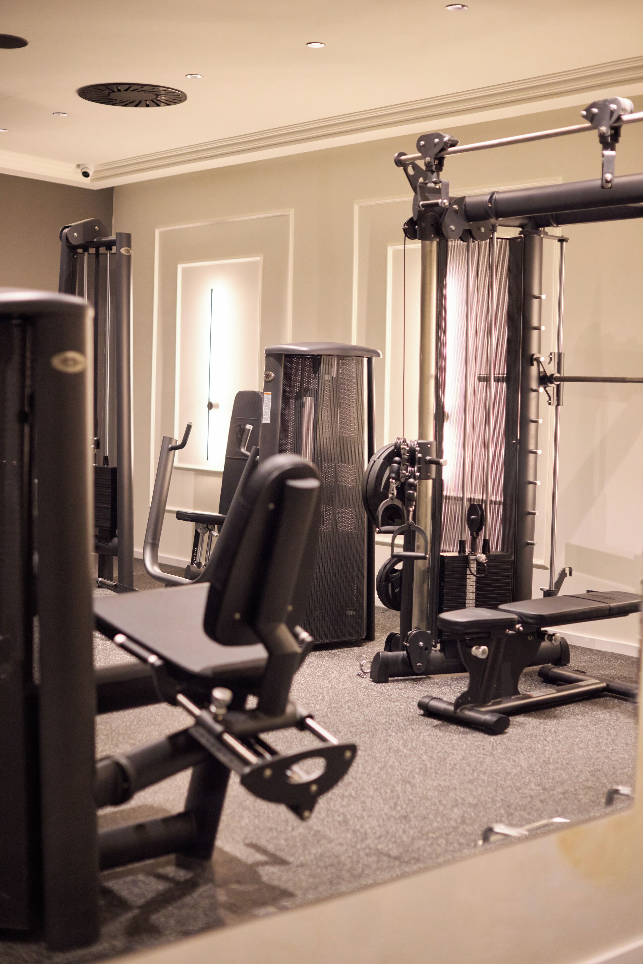 A gym with various exercise machines and a door in the background.