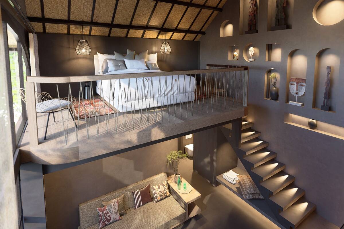 A modern interior with a high ceiling, a mezzanine level, a staircase, and a variety of wall-mounted art pieces.