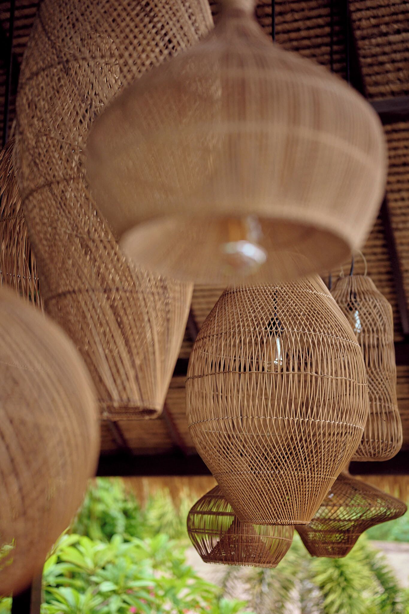 A close-up of woven, spherical light fixtures with a natural, textured appearance.