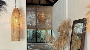 A modern bathroom with a large bathtub, woven ceiling, and large mirrors. - Hani Hideaway (Gili Air)
