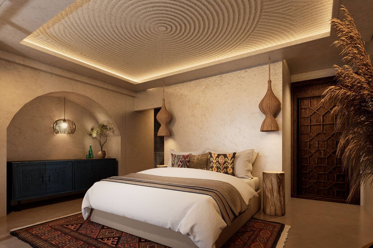A bedroom with a large bed, a patterned rug, a wooden cabinet, and a decorative ceiling.