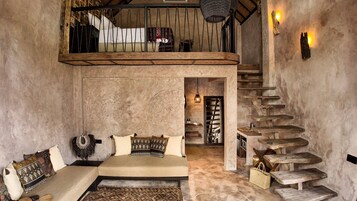A room with a loft bed, a staircase, and a rustic decor.