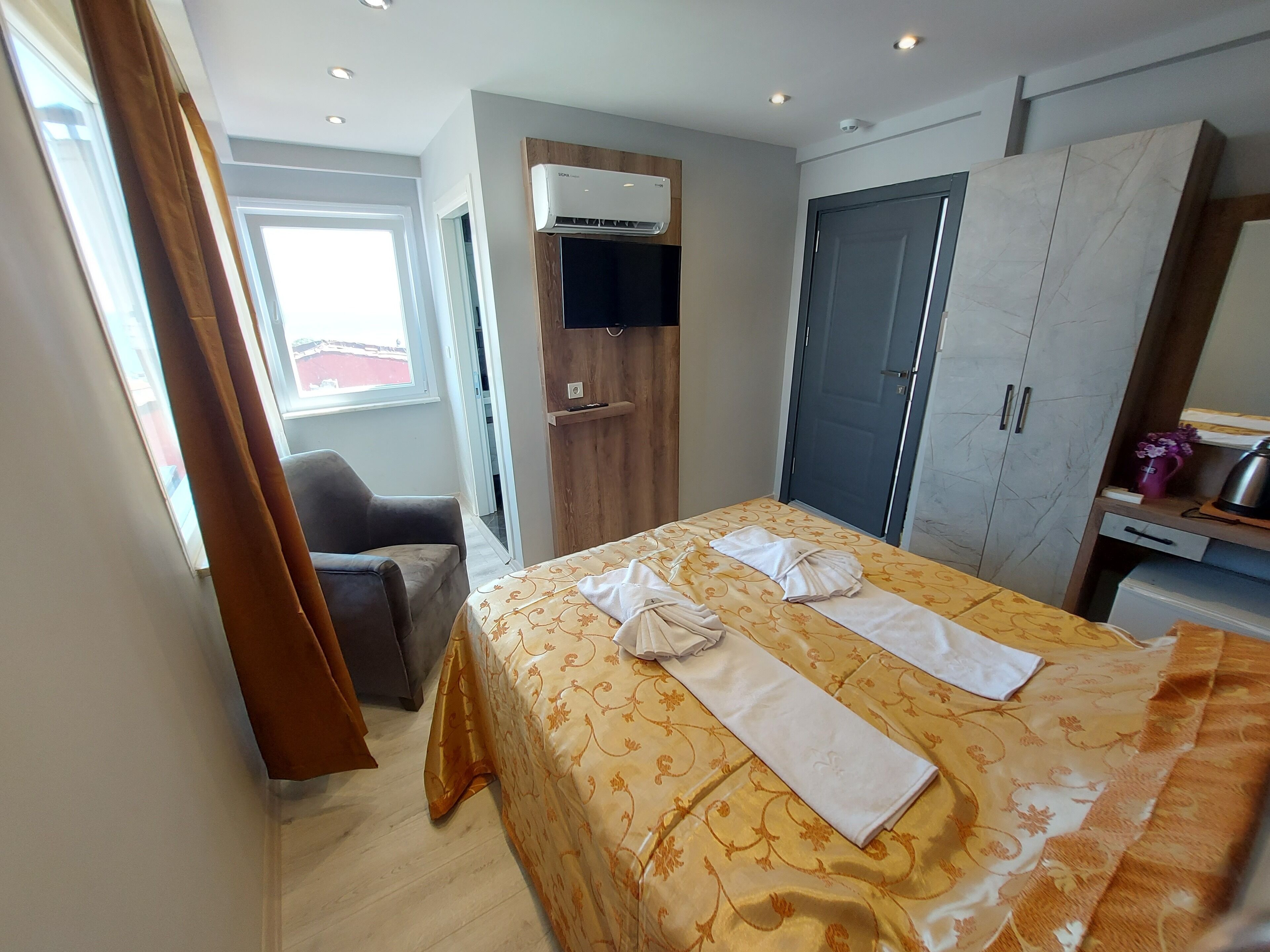 Habitación de hotel con cama, una silla, armario y televisión.