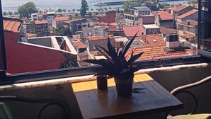 Ein Balkon mit Blick auf eine Küstenstadt, einschließlich Gebäude und Meer.