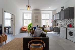 Un apartamento moderno con sala de estar, cocina y lavandería.