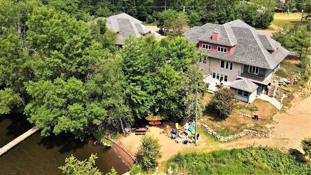 A large house with a dock, surrounded by dense forest and a river. - Long Lake North Periwinkle (Phillips)