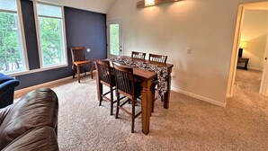 A dining area with a table and chairs, a ceiling fan, and a view through the window. - Long Lake North Periwinkle (Phillips)