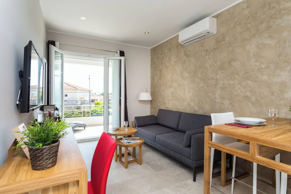 Un salon moderne avec un canapé, une table à manger et une plante en pot.