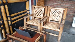 Una silla de bambú con un ordenador portátil encima.